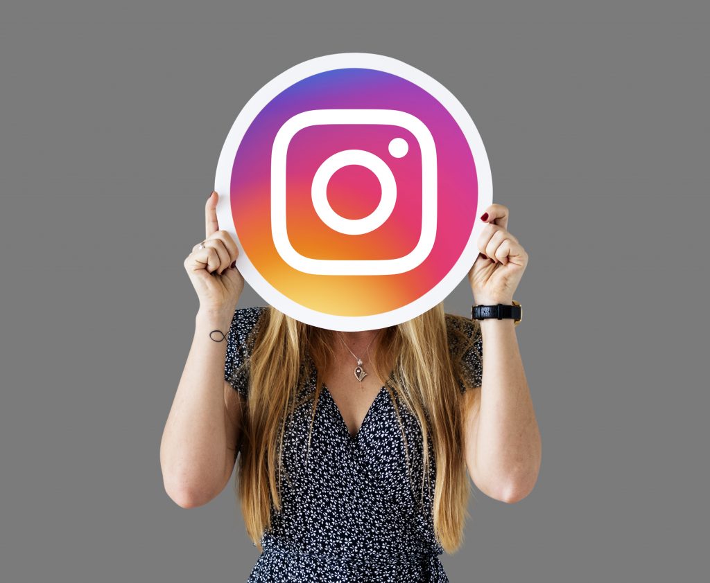 Mulher com o símbolo do Instagram em mãos